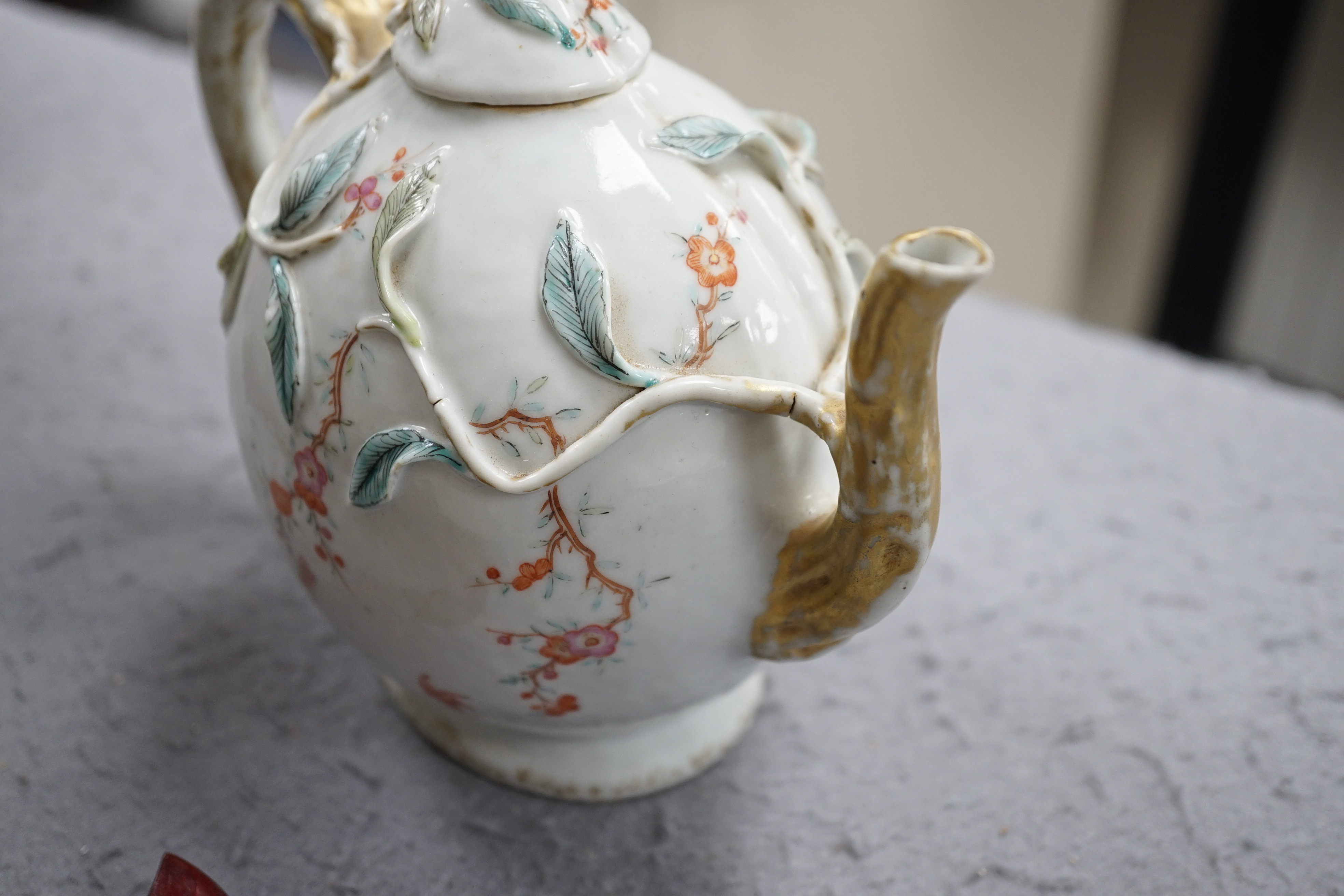 A Chinese enamelled porcelain peach-shaped teapot, Qianlong period (1736-95), wear to gilding